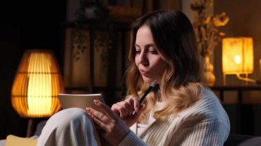 Düşünceli Kafkasyalı genç bir kadın akşamları not defterine yazıp not alıyor. Fikirleri not etmek, zaman çizelgesi oluşturmak ve strateji planlamak.