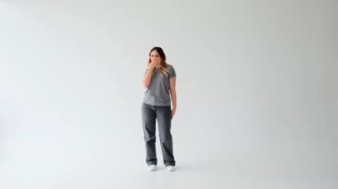 Beyaz arka planda tek başına duran mutlu ve romantik Kafkasyalı genç bir kadın hava öpücüğü yolluyor. Şefkat, arzu, flört kavramı.