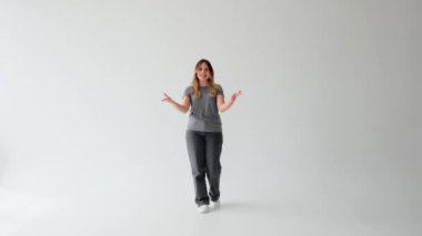Beyaz arka planda internet sosyal medyası için çevrimiçi yayın yapan ya da video kaydeden neşeli beyaz kadın blogcu.