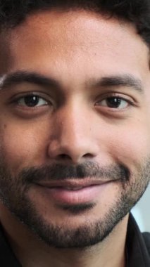 Kameraya bakan gülümseyen Orta Doğulu bir erkek çalışanın yakın portresi. Mutlu insanlar ya da personel kavramı. Dikey video.