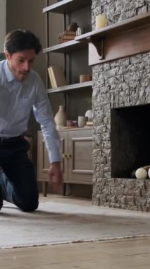 Arkadaş canlısı Kafkasyalı genç, serbest yetişkin bir erkek evde antrenman arasında şınav çekiyor. Sağlıklı yaşam tarzını sürdürme kavramı. Dikey video.