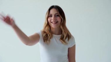 Dost canlısı ve neşeli beyaz kadın beyaz arka planda anlaştık işareti gösteriyor. Onayla ya da kabul et, iyi seçim ya da karar kavramı.