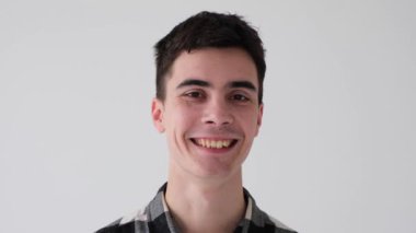 Beyaz arka planda mutlu ve neşeli bir portreye yakın durun. İnsanların kişiliği ve basitliği. Olumlu duygular kavramı.