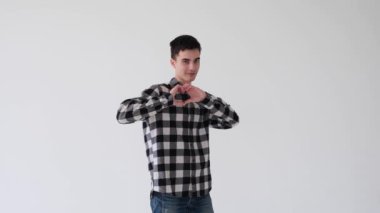 Oyuncu, mutlu ve beyaz arka planda kalp şeklinde bir jest gösteren beyaz aşık beyaz bir adam. Şefkat, arzu ve mutluluk..
