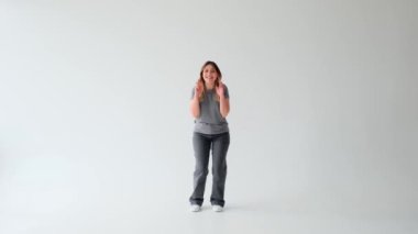 Tatmin olmuş ve neşeli, beyaz arka planda umut içinde bekleyen beyaz, beyaz, genç, yetişkin bir kadın. Arzu ya da dilek hareketi.