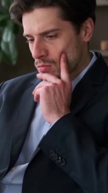 Kafkasyalı genç, serbest çalışan bir erkeğin portresi internette geziniyor ya da evde cep telefonu kullanarak sohbet ediyor. Dikey video.