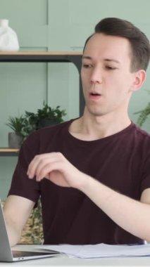 İnternette gezinen ya da bilgisayarla sohbet eden, boş zamanlarını evde ya da ofiste geçiren mutlu, genç beyaz bir adam. Dikey video.