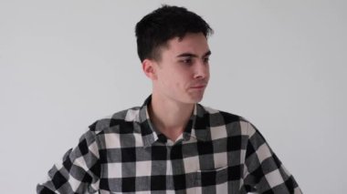 Gergin ve endişeli beyaz bir gencin portresi. Şüphe içinde beyaz arka plan üzerinde kafa yoruyor. Seçenekler bulmak, zor seçimler yapmak.