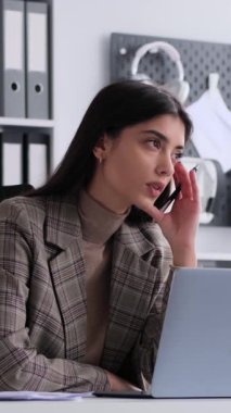 Ofiste çalışan düşünceli, beyaz, genç, yetişkin bir kadın çalışan. Analiz projesi kavramı ve tasarruf hesapları. Dikey video.