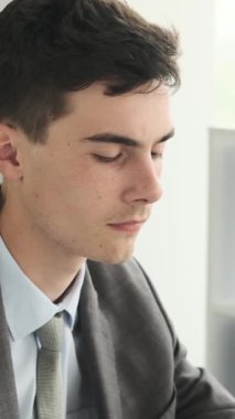 Ofiste çalışan Kafkas asıllı genç, yetişkin bir ofis çalışanının portresi. Profesyonel iş adamı ya da girişimci. Dikey video.