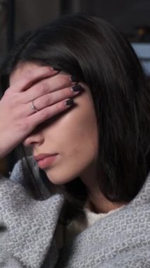 Depresyonda ve üzgün genç beyaz bir kadının portresi evde duygusal stres altında. Dikey video.