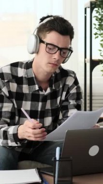 Belgelerle çalışan Stern Kafkas 'lı genç bir adam. Muhasebe işi yapıyor ve evde planlama stratejisi uyguluyor. Dikey video.