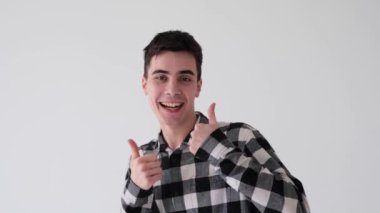 Beyaz arka planda olumlu ve gülümseyen beyaz bir adam onaylama ve dansla onaylama jesti gösteriyor. Başarı kutlaması.