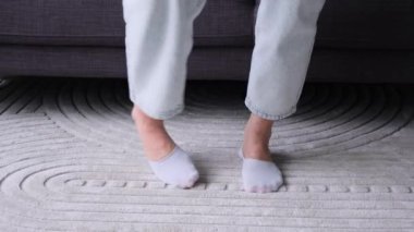 Kafkasyalı bir kadının oturma odasında bacak egzersizi yaparken yakın plan çekimleri. Spor ya da spor eğitimine hazırlanma kavramı.