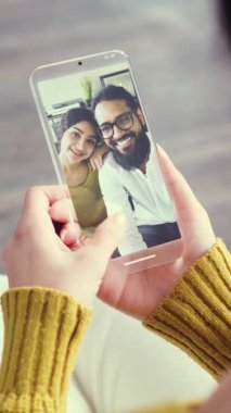 Sosyal medyada fotoğraflardan hoşlanan bir kadının AR ve VFX efektli fütürist telefon kullanarak fotoğrafını yakından çek. Dikey video.