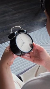 Kafkasyalı bir kadının evdeki saati değiştirdiği yakın çekim. Yazın veya kışın dönüşüm kavramı. Dikey video.