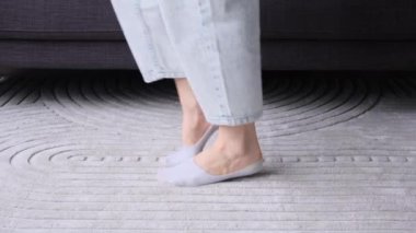 Kafkasyalı bir kadının yakın çekim görüntüleri evde koşuyor, ısınıyor ve esneme egzersizleri yapıyor. Esneklik kavramı üzerine bacak eğitimi.