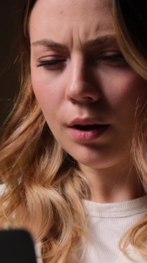 Akşamları evde dizüstü bilgisayarla iyi haber geçirmeyi kutlayan Kafkasyalı genç bir kadın. Dikey video.