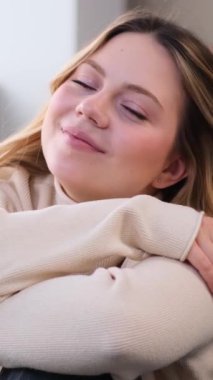 Evinde kameraya bakan gülümseyen ve iyimser bir beyaz kadının portresi. Kendinden emin ve memnun insanlar konsepti. Dikey video.