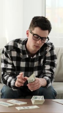 Şaşırmış genç, beyaz bir adam internete cep telefonuyla bakıyor ve 