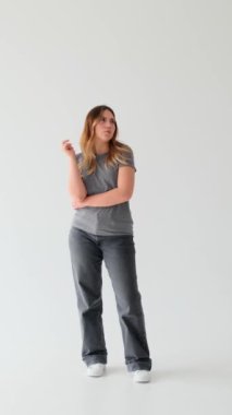 Neşeli, beyaz, genç, yetişkin bir kadın beyaz arka planda parlak fikirlere sahip. Hayal gücü, beyin fırtınası konsepti. Dikey video.