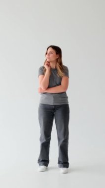 Düşünceli bir kadının beyaz arka plan hakkında parlak fikirleri var. İlham, evreka ve yaratıcılık kavramı. Dikey video.