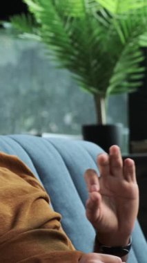 Smiley Ortadoğu 'lu adam evdeki bilgisayarı kullanarak online video görüşmesi sırasında konuşmaya başladı. Sosyal medya aracılığıyla iletişim kurma kavramı. Dikey video.