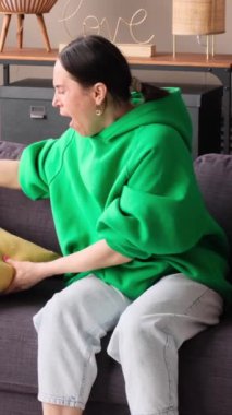 Yorgun orta yaşlı, beyaz bir kadın gündüz vakti kanepede uzanıyor. Oturma odasında uyuyor. Dinlenme ve rahatlama kavramı. Dikey video.