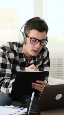 Kafkasyalı genç adam para saçıyor, refahı kutluyor ve evde eğleniyor. Finansal zenginlik kavramı. Dikey video.