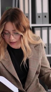 Mutsuz, genç, yetişkin, Kafkasyalı ofis çalışanı. Görüntülü konuşma yapıyor ve ofiste çalışıyor. Uzak buluşma kavramı. Dikey video.