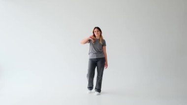 Beyaz arka planda başparmağını gösteren ya da hoşlanmayan mutsuz, beyaz bir beyaz kadın. Kısıtlama kavramı, onaylamama, reddetme.