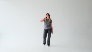 Beyaz arka planda başparmağını gösteren ya da hoşlanmayan mutsuz, beyaz bir beyaz kadın. Kısıtlama kavramı, onaylamama, reddetme.