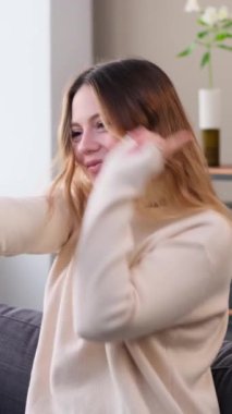 Olumlu Kafkasyalı genç bir kadın evde dans ve müzikle zaman geçiriyor. Hafta sonu boş zaman aktivitesi kavramı. Dikey video.