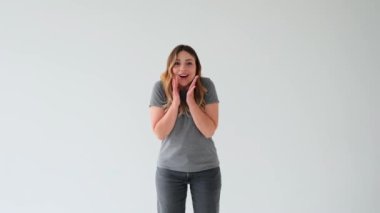 Beyaz arka planda başarıyı kutlayan ve evet diyen heyecanlı beyaz bir kadının portresi. Başarı kavramı, sürpriz, tatmin.