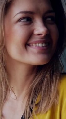 Gülümseyen ve tatmin olmuş bir kadının portresi evde huzurlu bir anın tadını çıkarıyor, pozitif duygular yayıyor ve sıcak ifadelerle tatmin oluyor. Dikey video.