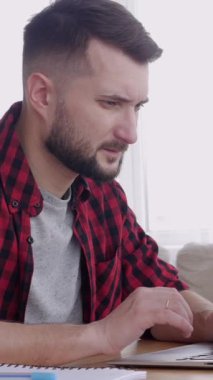 Orta yaşlı, Kafkasyalı bir işadamının merkez ofiste dizüstü bilgisayarla çalıştığını düşünüyor. Ağ kurma, istihdam ve işgal kavramı. Dikey video.
