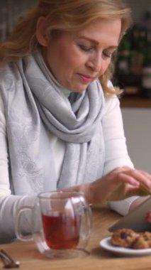 Çay içip, boş zamanlarını internet üzerinden tablet bilgisayar kullanarak, kafede dinlenerek geçiren heyecanlı Kafkasyalı son sınıf öğrencisi. Dikey video.