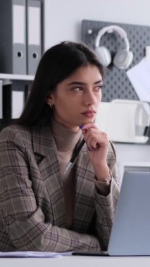 Ofiste dizüstü bilgisayarla çalışırken, Kafkas 'lı genç, serbest çalışan birinin parlak bir fikir üretmesi. Dikey video.