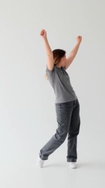 Beyaz arka planda başarıyı kutlayan ve evet diyen heyecanlı beyaz kadın. İyi haber ve başarı kavramı. Dikey video.