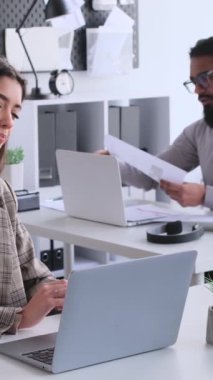 Ofiste birlikte iş yapan pozitif çok ırklı ofis çalışanları. Evrak işi, müzakere ve iş kavramı. Dikey video.