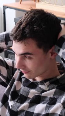 Hayal kırıklığına uğramış Kafkasyalı genç bir adam kafasını kaşıyor ve evde rahatsızlıktan muzdarip. Kepek ya da hassas deri kavramı. Dikey video.