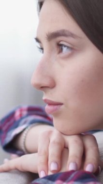 Evdeki kanepede uzanmış rüya gören genç, mutlu beyaz bir kadın. Hayal gücü, düşünce ve tefekkür konsepti. Dikey video.