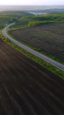Yazın kırsal ya da vadiden geçen arabaların olduğu bir otoyol manzarası. Doğanın güzelliği ve kırsal alan. Dikey video.