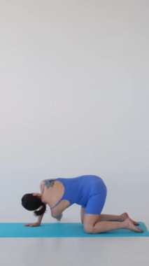 Neşeli orta yaşlı beyaz hamile kadın beyaz arka planda pilates ya da fitness eğitimi yapıyor. Hamilelik ve egzersiz kavramı. Dikey video.