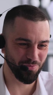 Ofisteki müşteriyle uzaktan konuşma yapan arkadaş canlısı bir müşteri destek operatörü. Çevrimiçi müzakere ya da danışmanlık kavramı. Dikey video.