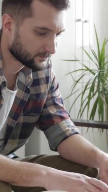 İnternette çalışırken ya da öğrenirken bilgisayarda yazı yazan, merkez büroda oturan orta yaşlı, beyaz bir adam. Dikey video.