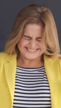 Bunalmış bir kadın siyah arka planda başarı ve iyi haberi kutluyor. Zafer, şok ve olumlu duyguların neşeli ifadesi. Dikey video.