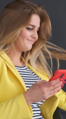 Sosyal medyada siyah arka planda telefonla mesajlaşan sürpriz bir kadın. Boş zaman ve internet iletişimi anlamlı duygularla. Dikey video.