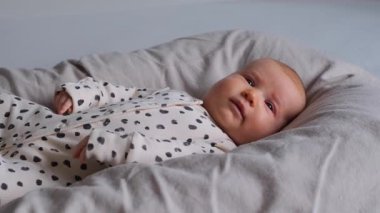 Yeni doğmuş bebek, evde bir beşikte huzur içinde yatıyor sıcaklığı, büyümeyi ve bebekliğin ilk evrelerini kucaklıyor. Bebek, çocukluk ve ergenlik zamanlarından zevk alır..