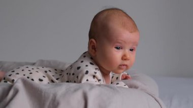 Yeni doğmuş çocuk evde yatıp merakla etrafına bakıyor. Bebeklik, büyüme ve keşfin ilk safhalarında çocukluk ve bebeklik.